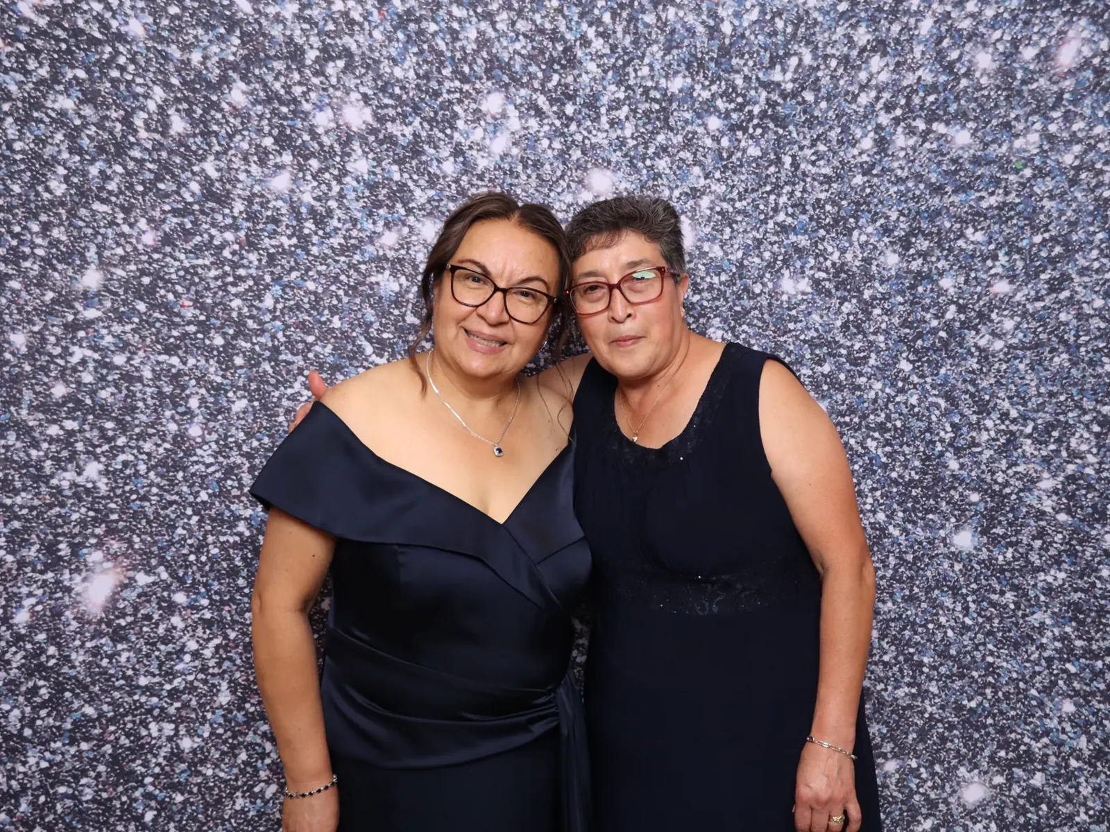 Guests posing in front of a silver sequin photo booth backdrop in Chicago