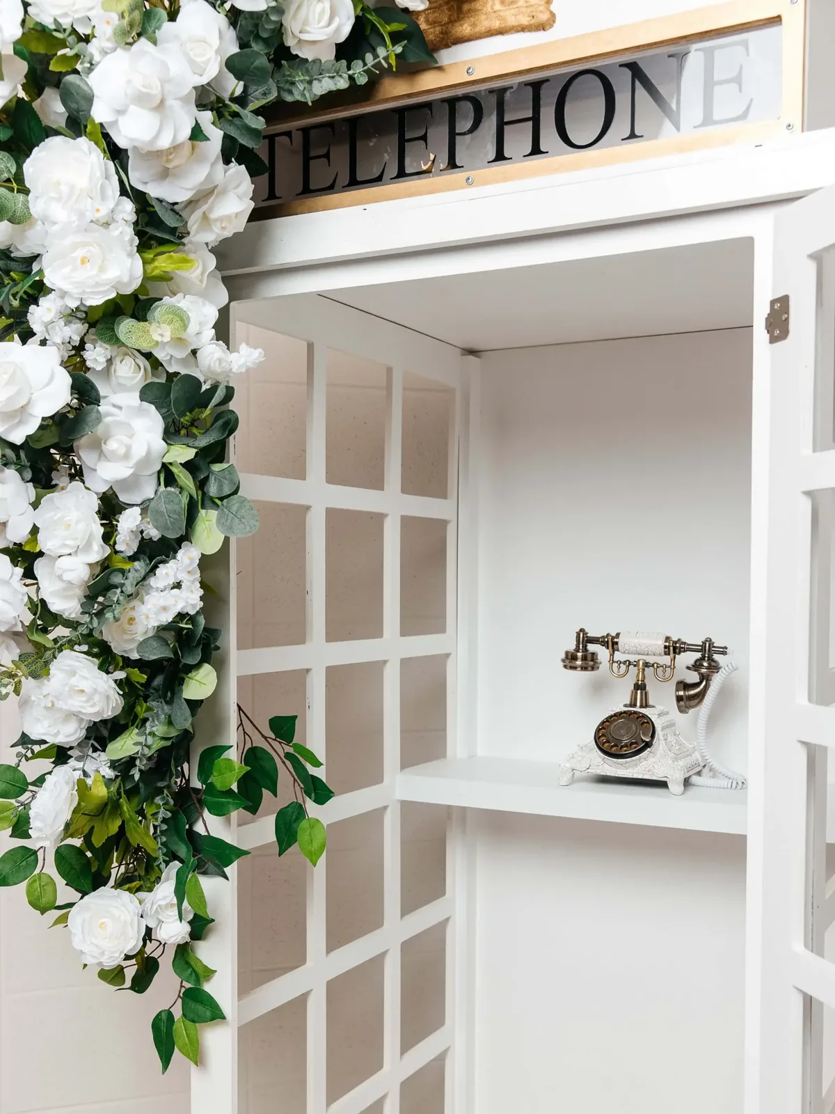 Detail of the telephone booth sign and floral arch