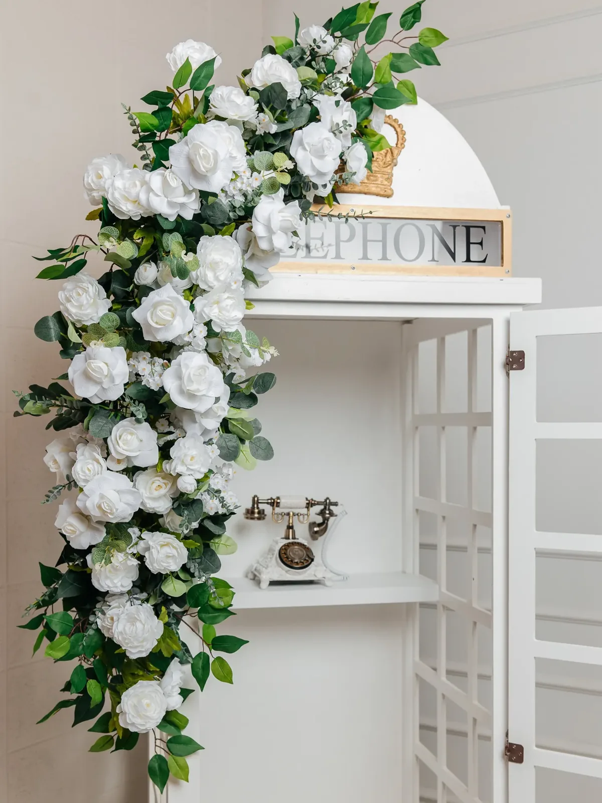 Telephone booth audio guestbook dressed with white florals